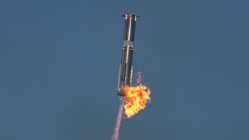 SpaceX's mega-rocket Starship booster returns to the launch pad during a test flight from...