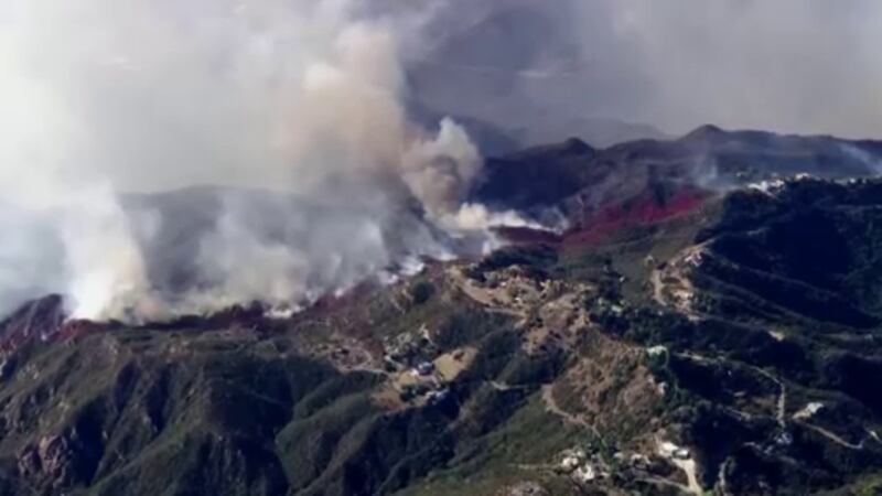Aerial view of heavy white and black smoke burning from the mountains in Malibu.