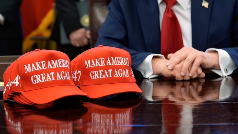 Hats are seen on the desk as President Donald Trump speaks with reporters after signing...