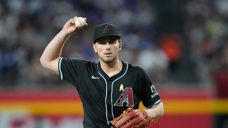 Arizona Diamondbacks starting pitcher Brandon Pfaadt looks to toss a baseball out of play...