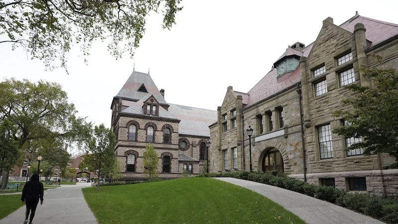 A pedestrian walks along a path on the campus of Brown University, in Providence, R.I.,...