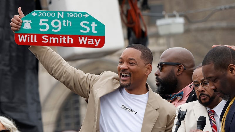 Will Smith holds up a street sign during a ceremony to name a street after him in West...