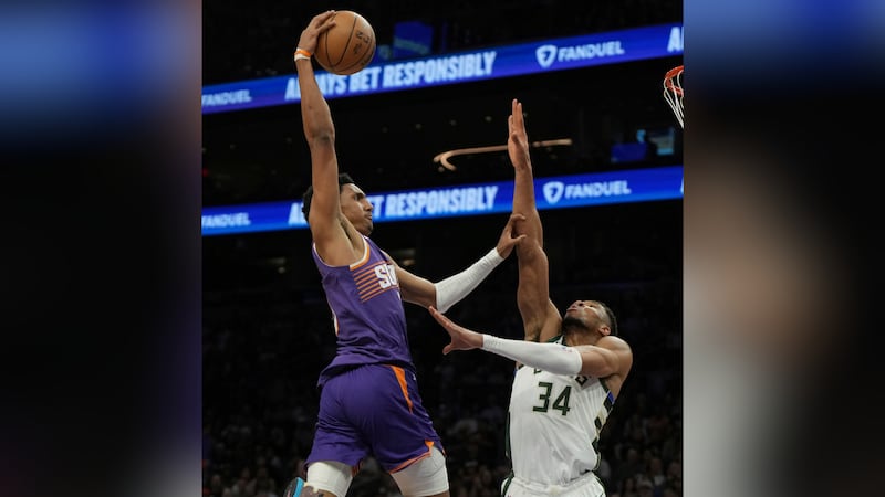 Phoenix Suns forward Ryan Dunn, left, shoots over Milwaukee Bucks forward Giannis...