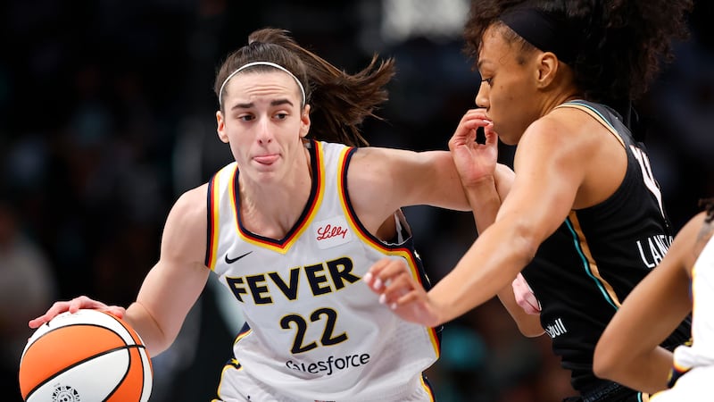 Indiana Fever guard Caitlin Clark (22) drives to the basket against New York Liberty forward...