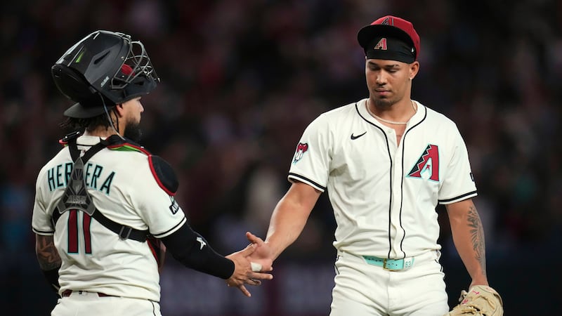 Arizona Diamondbacks pitcher Justin Martinez, right, celebrates a win against the Atlanta...