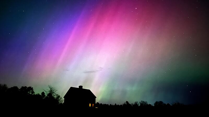 FILE - The northern lights flare in the sky over a farmhouse, May 10, 2024, in Brunswick, Maine.