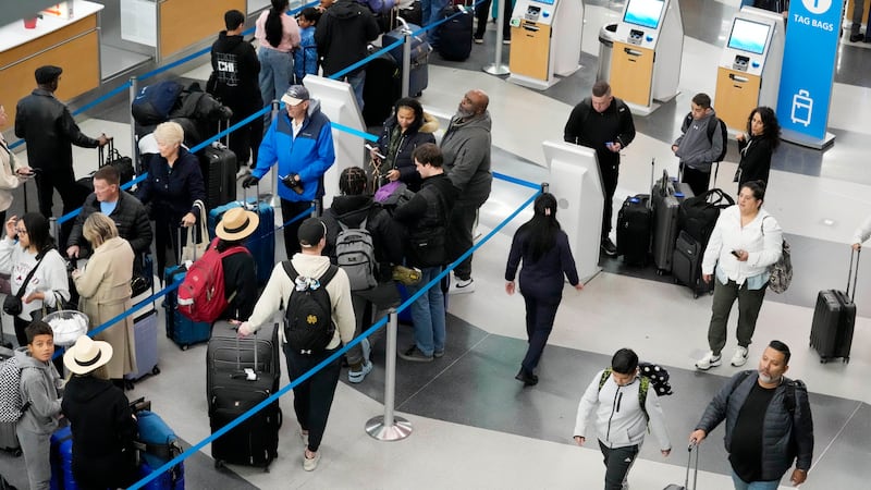 Travelers wait to drop off their bags and walk through Terminal 3 at O'Hare International...