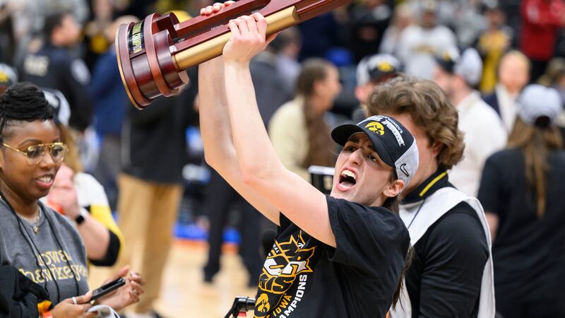 Iowa guard Caitlin Clark shows off the trophy as she celebrates after an Elite 8 college...