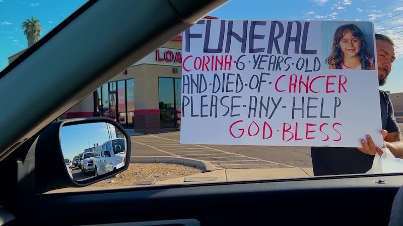 Photo inside of a car driving on Indian School road in Phoenix, AZ and a man outside holding...