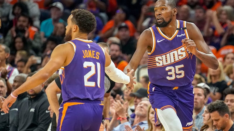 Phoenix Suns guard Tyus Jones (21) slaps hands with Kevin Durant (35) after Durant scored...