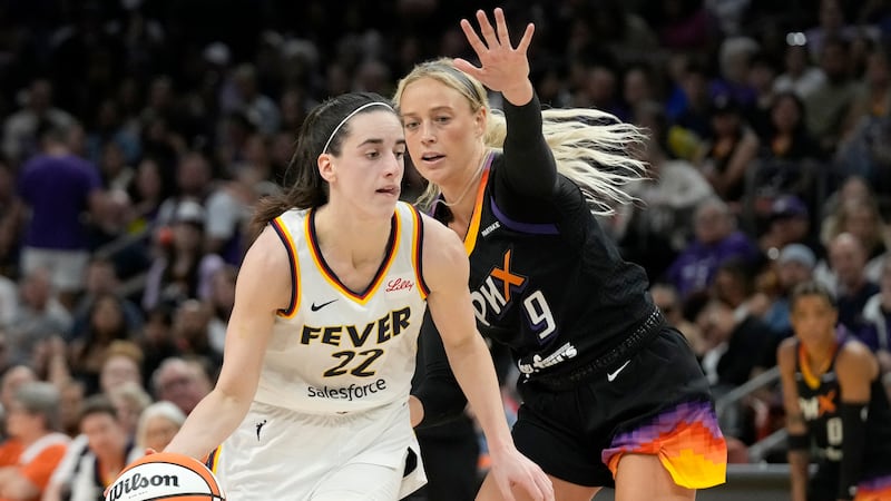 Indiana Fever guard Caitlin Clark (22) dribbles past Phoenix Mercury guard Sophie Cunningham...
