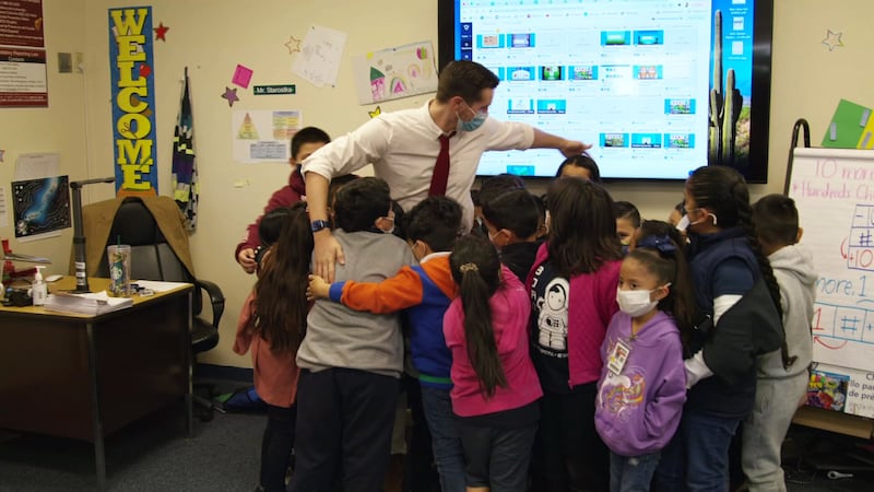 This picture shows Philip Starostka and his students in a group hug.