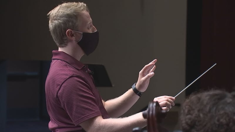 This photos shows Ryan Diefenderfer conducting his music students.