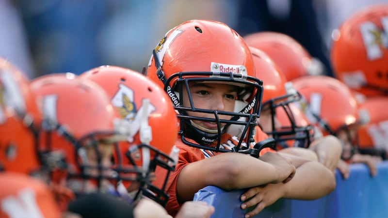 FILE - Pop Warner football players look on before an NFL pre-season football game between the...