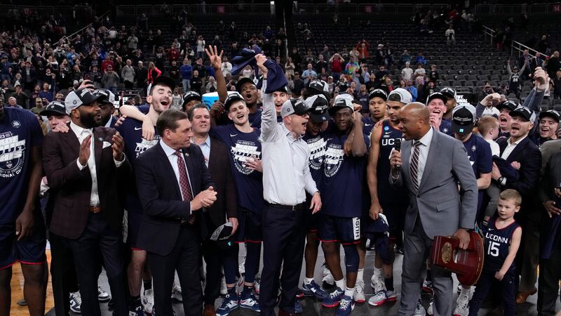 UConn head coach Dan Hurley, middle, celebrates with his team after the 82-54 win against...