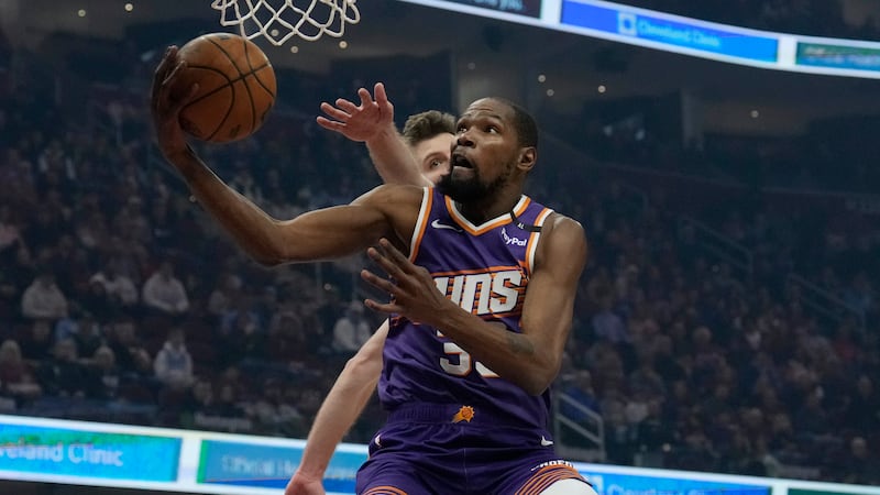 Phoenix Suns forward Kevin Durant, front, goes to the basket past Cleveland Cavaliers forward...