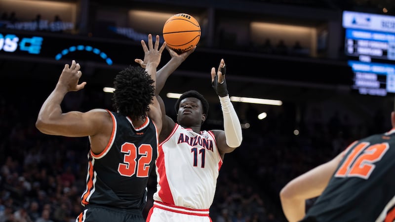 Arizona center Oumar Ballo (11) scores a basket over Princeton forward Keeshawn Kellman (32)...