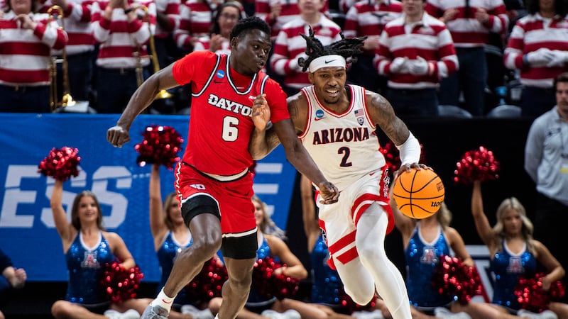 Arizona guard Caleb Love (2) brings the ball up court while guarded by Dayton guard Enoch...