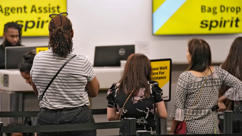 FILE - Passengers wait in a line for help at the Spirit Airlines ticket counter at the Tampa...