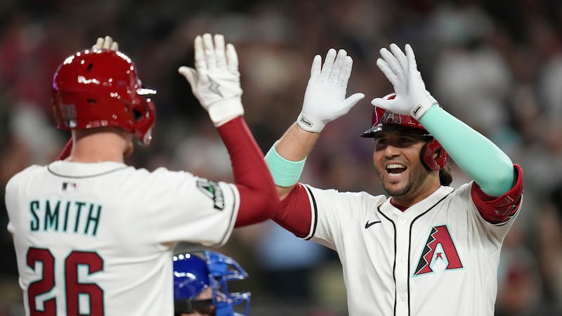 Arizona Diamondbacks' Eugenio Suárez, right, smiles as he celebrates his two-run home run...